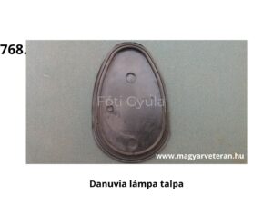 Ovális alakú fekete gumialkatrész három kör alakú nyílással, zöld háttéren elhelyezve; Danuvia motorkerékpár lámpatalp része, veterán jármű katalógusból.
